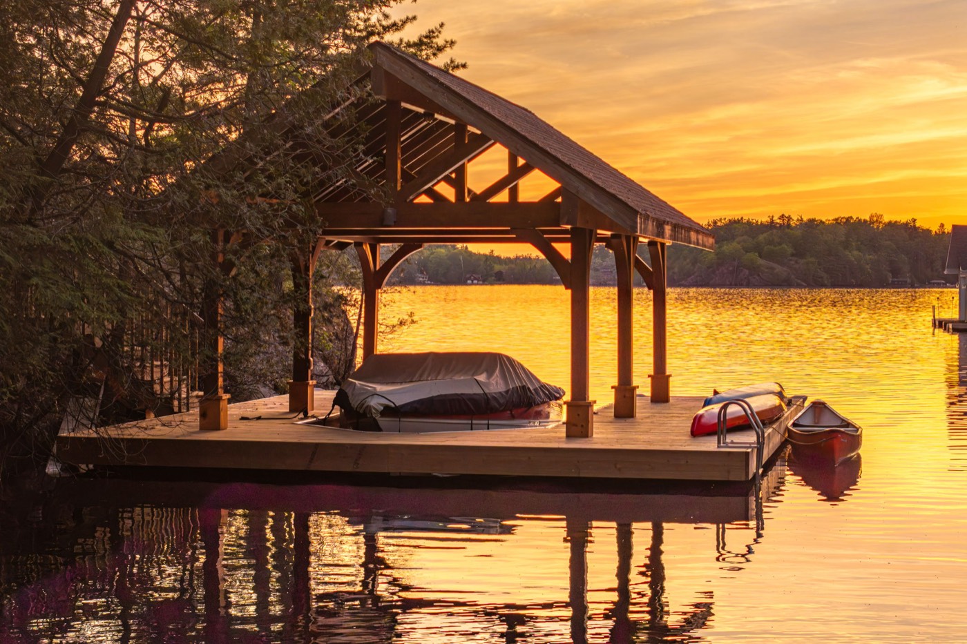 Covered boathouse on Lake Muskoka at golden hour
